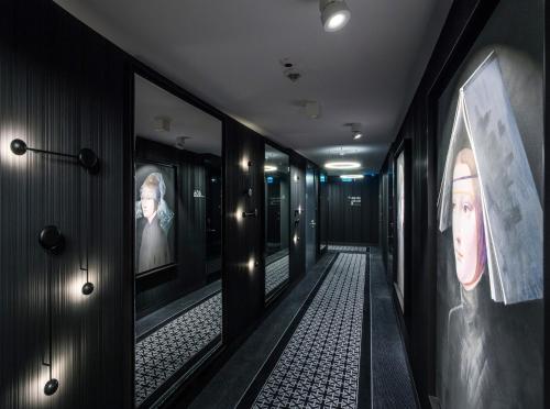 a hallway with pictures of people on the walls at Hotel Indigo Warsaw Nowy Świat by IHG in Warsaw