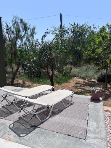 two lounge chairs and an umbrella on a deck at FinIQ Boutiq Studios in Foiníki