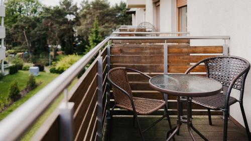 two chairs and a table on a balcony at Wczasowa, Sun & Snow in Ustka