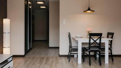 a dining room with a white table and chairs at Wczasowa, Sun & Snow in Ustka