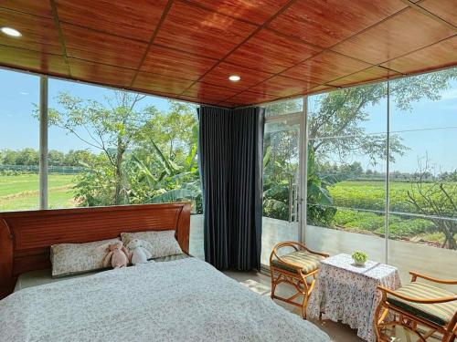a bedroom with a bed and a large window at Lúa homestay in Hue