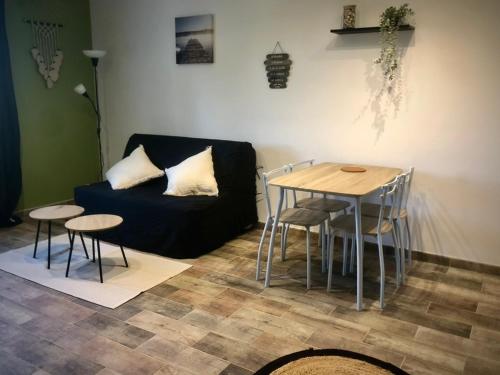 un salon avec un canapé, une table et des chaises dans l'établissement location studio Presqu'ile de Giens, à Hyères