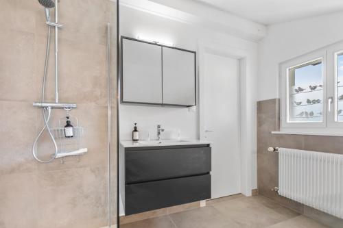 a bathroom with a sink and a shower at Attique rénové avec jacuzzi 6 pers à Savièse in Savièse