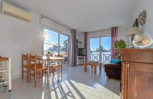 une salle à manger et un salon avec une table et des chaises dans l'établissement Appartement 6 personnes à Saint Raphaël Valescure Piscine Tennis Pétanque, à Saint-Raphaël