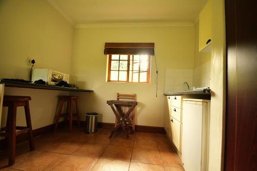 a kitchen with a sink and a table and a window at Chillifields Guesthouse in Hillcrest