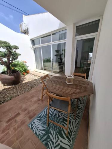 a wooden table and chairs sitting on a patio at Cosy Guest House - Villa das Alfarrobas in Algoz