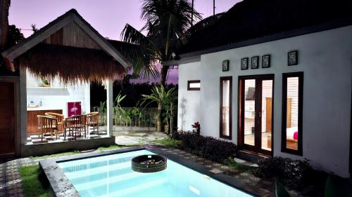 a house with a swimming pool in the yard at Oka Cottage in Nusa Penida