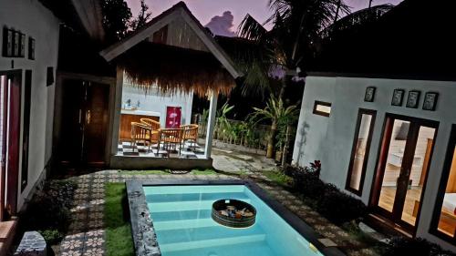 a small swimming pool in the yard of a house at Oka Cottage in Nusa Penida