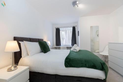 Un dormitorio con una cama grande con una manta verde. en Quayside Stay, en Gateshead