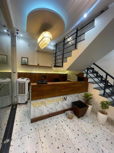 a lobby with a staircase with a sign that reads acceleration at Hotel Alpine Inn in Dera Bassi