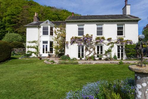 a white house with a green yard at Haverbrack Country House in Beetham