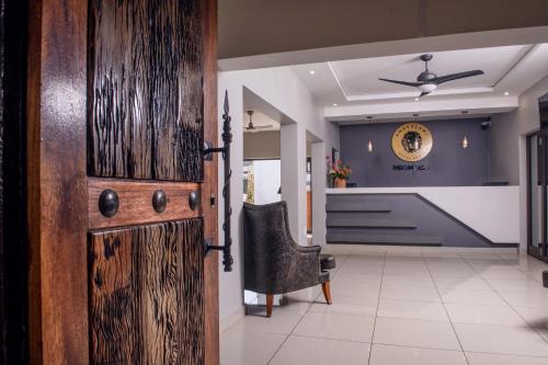 a hallway with a wooden door and a chair at Khayalami Hotel - Mbombela in Nelspruit