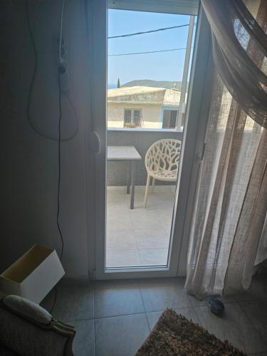 an open door to a patio with a table and a chair at Apartmani Sabotic in Sutomore