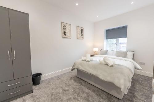 a white bedroom with a bed and a window at Luxury Stay by City Centre Etihad and COOP Live in Manchester