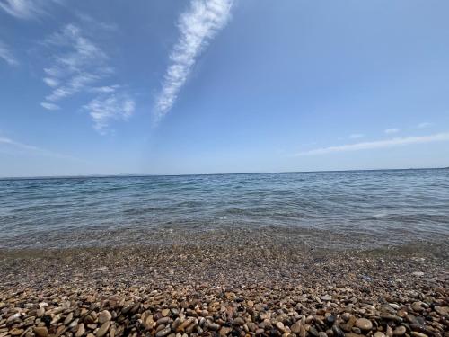 a rocky beach with the ocean in the background at Mare Calmo Studios, Chios in Chios