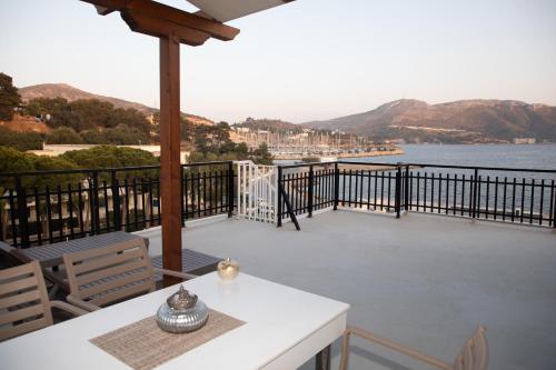 a balcony with a table and chairs and a view of the water at White Heaven in Lakkíon