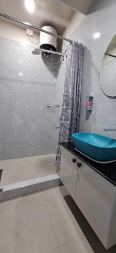 a bathroom with a blue sink and a shower at Hotel Jay Jay in Āīzawl