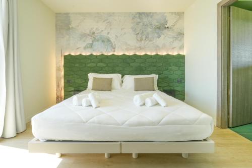 a large white bed in a white room at Hotel Vita in Salò