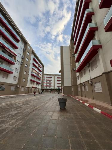 an empty street between buildings with a bucket in the middle at Modern and family-friendly apartment in Birkhadem in Birkhadem