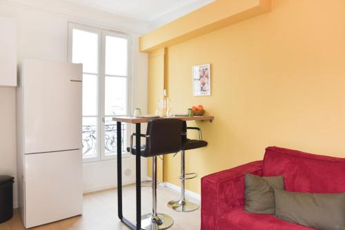 un salon avec un canapé rouge et une table dans l'établissement Apartment for 4 - near Square des Batignolles, à Paris