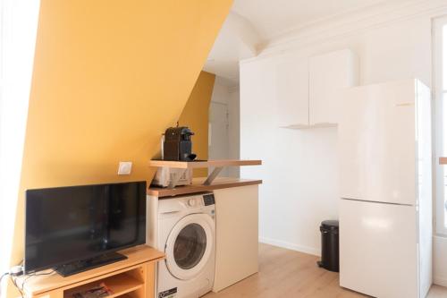 - une buanderie avec un lave-linge et une télévision dans l'établissement Apartment for 4 - near Square des Batignolles, à Paris