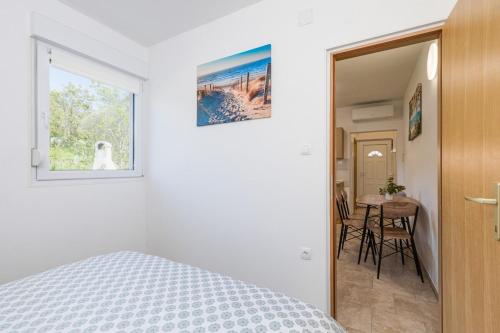 a bedroom with a bed and a window and a table at Lara apartment for two in Skrbčići