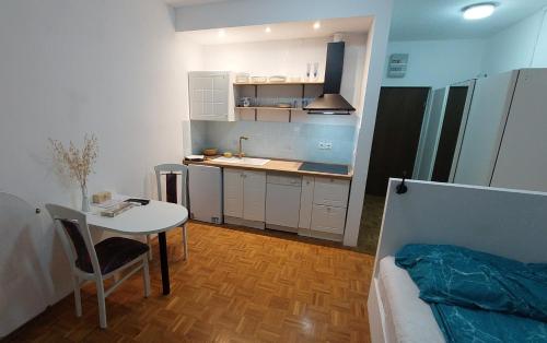 a small kitchen with a table and a bed in a room at Studio apartma Plaža in Portorož
