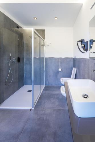 a bathroom with a shower and a sink and a toilet at Hotel Vita in Salò