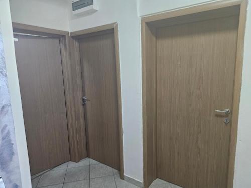 two wooden doors in a room with at Apartmani Sabotic in Sutomore