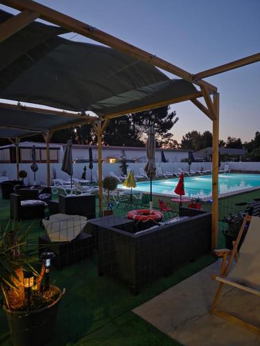 a pool with chairs and umbrellas and a swimming pool at Quinta da Mariazinha in Fernao Ferro