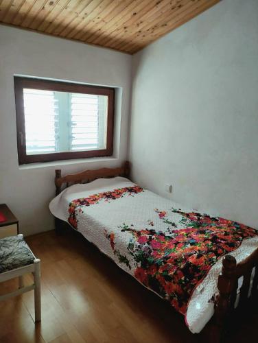 a bedroom with a bed with a quilt on it at On the beach apartments PAG in Dinjiška