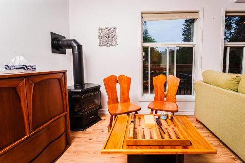 a living room with a couch and a stove at Le Chalet Blanc, bord de lac & spa in Saint Adolphe D'Howard