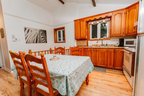 a kitchen with a table and a kitchen with wooden cabinets at Le Chalet Blanc, bord de lac & spa in Saint Adolphe D'Howard
