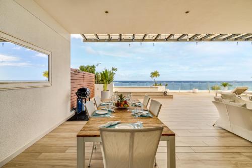 a dining room with a table and a view of the ocean at Cap Ouest by Horizon Holidays in Flic-en-Flac