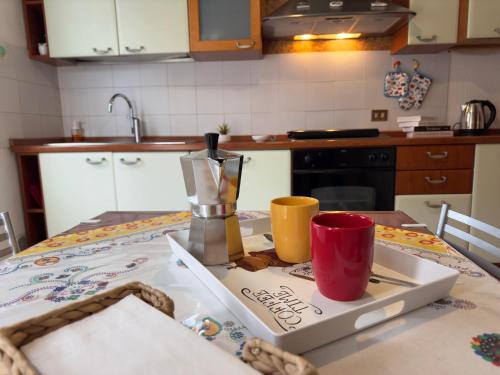 a kitchen table with a tray with two cups on it at Tavernola Suites - A due passi dal Traghetto in Como