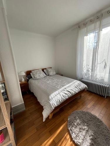 a bedroom with a bed and a large window at Séjour entre ville et montagnes Appartement 90 m2 in Thann