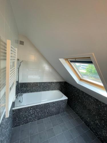 une salle de bain avec une baignoire et une fenêtre dans l'établissement Maison Cosy à Chartres, à Chartres