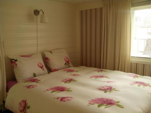 a bed with pink flowers on it in a bedroom at Apartment Boven Jan 572 in Den Helder