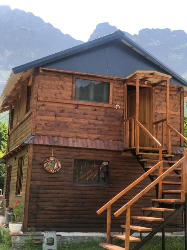 a log cabin with a staircase in front of it at Bujtina Diti in Tropojë