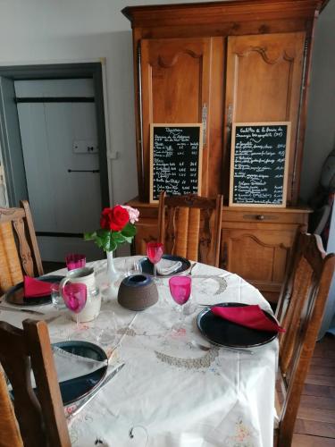 a dining room table with a white tablecloth and roses on it at Le Pigeonnier - Chambres d'hôtes in La Roche-Posay
