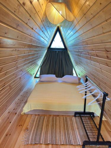 a bed in a tiny house with a window at Magical space Tsikhisdziri in K'obulet'i