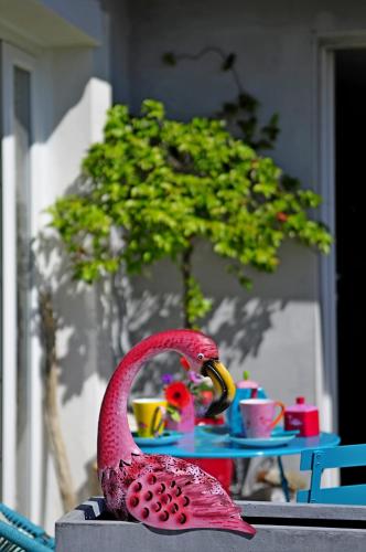 a red bird statue sitting on top of a table at B&B La Terre Brûlée in Aigues-Mortes