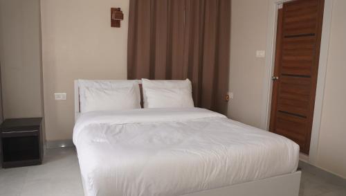 a bed with white sheets and pillows in a room at Hotel Jay Jay in Āīzawl