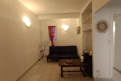 un salon avec un canapé noir et une table dans l'établissement Bright apartment in the heart of Perpignan, à Perpignan