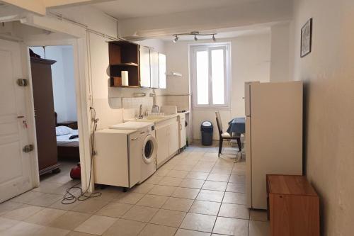 La cuisine est équipée d'un lave-linge, d'un évier et d'un réfrigérateur. dans l'établissement Bright apartment in the heart of Perpignan, à Perpignan
