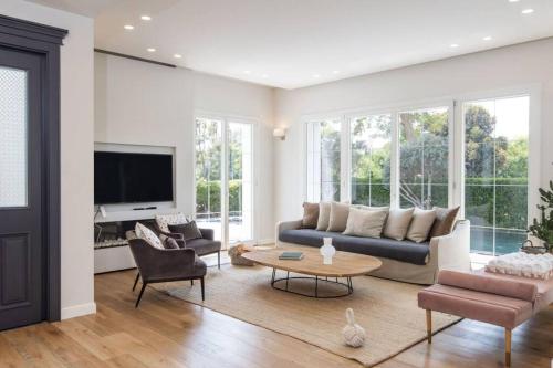 a living room with a couch and a table at Carmelo Congress Villa in Herzliya Pituah