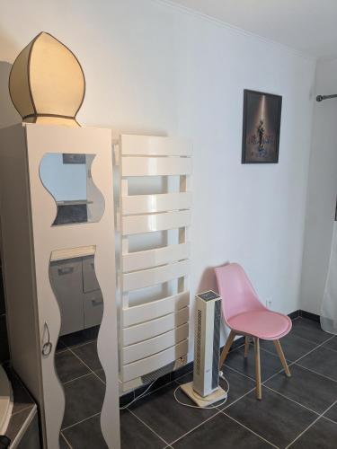 une pièce avec une chaise rose et une commode dans l'établissement studio ensoleillé, à Beaucaire