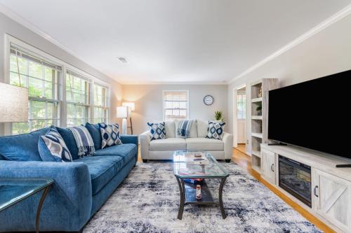 グリーンズボロにあるSouthern Charm 2BR Greensboro Nestの青いソファと薄型テレビのあるリビングルーム