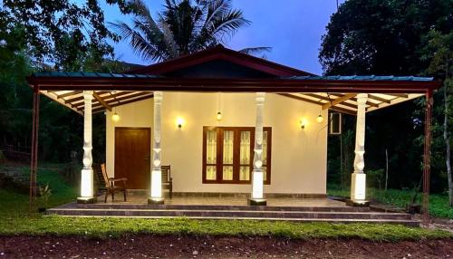 una pequeña casa blanca con techo en Mendis Villa, en Kosgoda