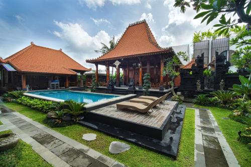 a house with a swimming pool in a yard at Pendopo Canggu Village in Canggu